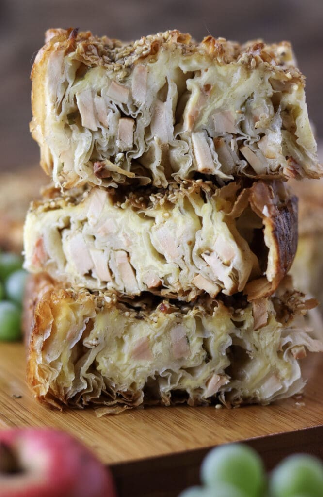 Three slices of chicken of the woods pie stacked on top of each other with flaky, golden phyllo pastry used in chicken of the woods recipe